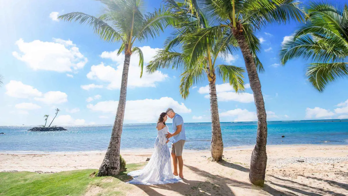 A family posing for a professional photographer on a Maui beach photoshoot with vibrant sunset colors